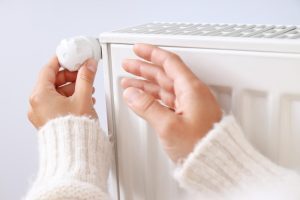 Une femme active la vanne thermostatique son radiateur
