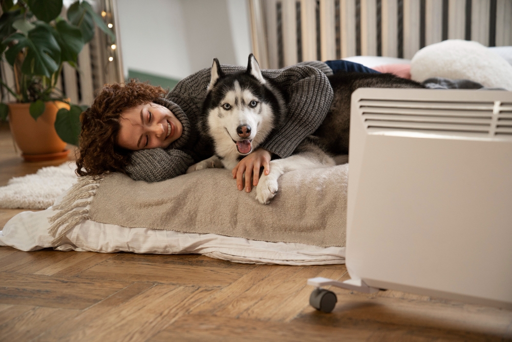 Un radiateur électrique mobile qui réchauffe une femme et un chien 