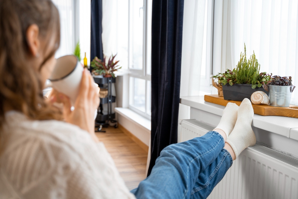 Une femme devant son radiateur