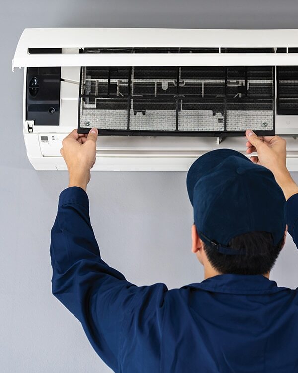 Un technicien Logista Hometech entretient le filtre d'un climatiseur réversible