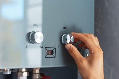 Un plombier chauffagiste Logista Hometech règle un chauffe-eau solaire