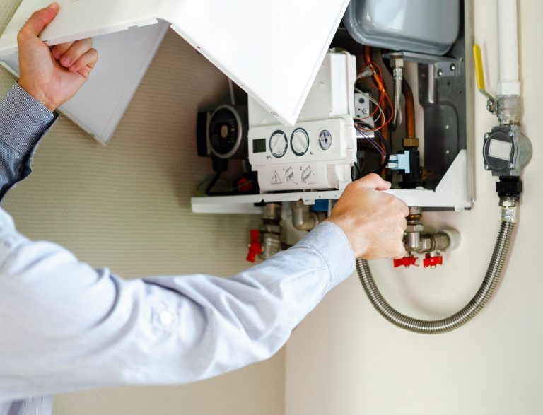 Un plombier chauffagiste Logista Hometech entretient un chaudière gaz