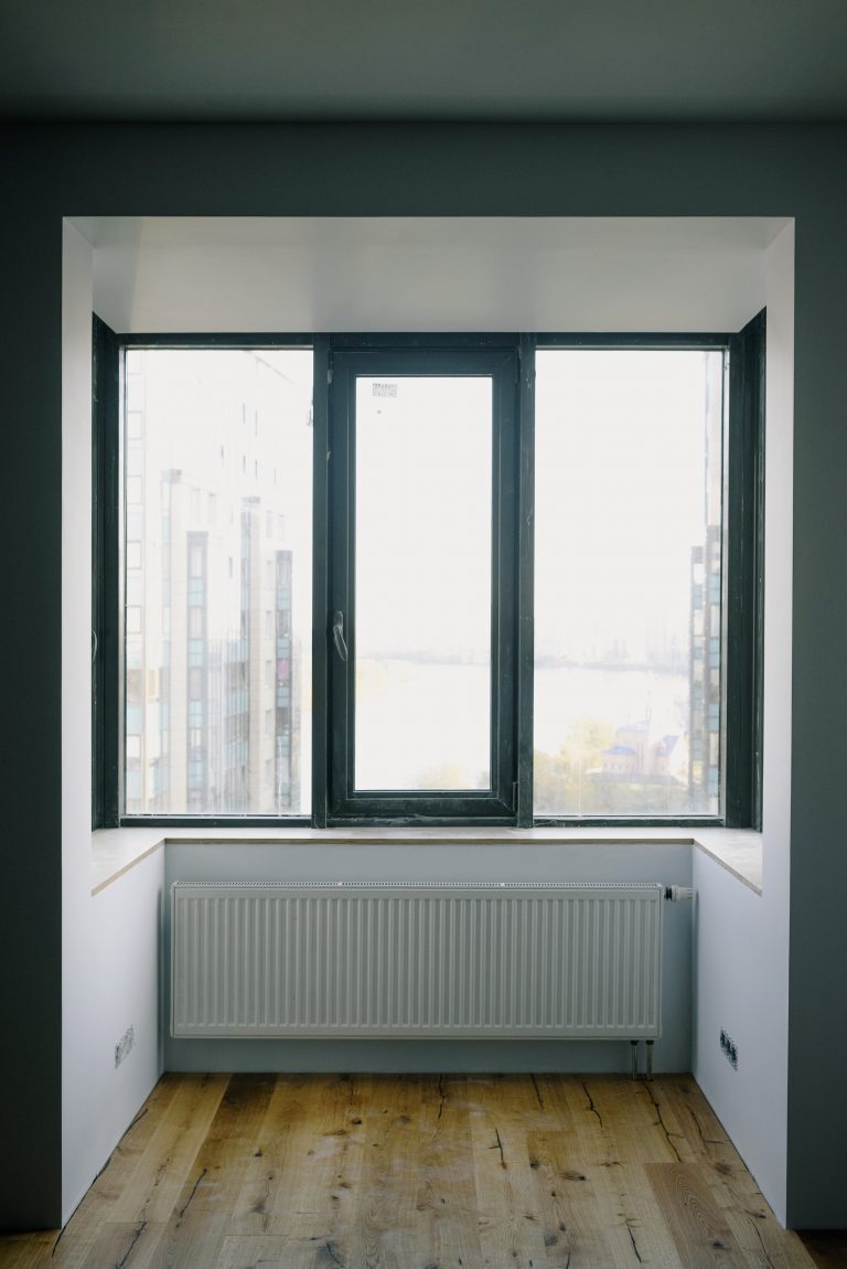 Radiateur plinthe en dessous d'une fenêtre dans une maison