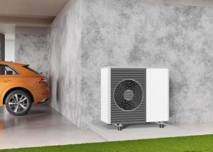 Une pompe à chaleur air/eau près du garage d'une maison
