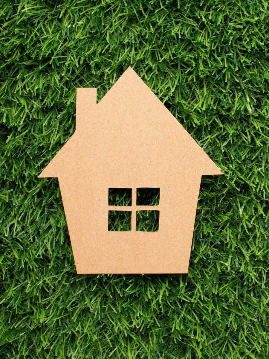 Une maison en carton dans l'herbe, symbolisant la rénovation énergétique